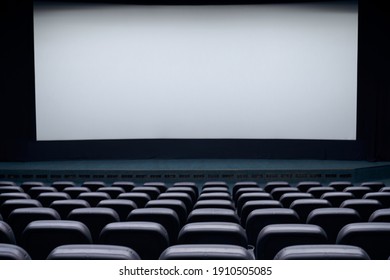 Interior Cinema Hall With White Screen And Black Comfortable Chairs. Concept Of Empty Cinema Hall.