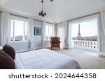 Interior of classic modern bedroom of a hotel or apartment condominium with beautiful views of Paris cityscape.