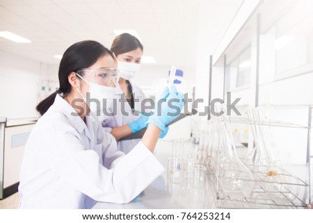Interior of clean modern white medical or chemistry laboratory background. Laboratory scientists working at a lab with test tubes. Laboratory concept with Asian woman chemists.