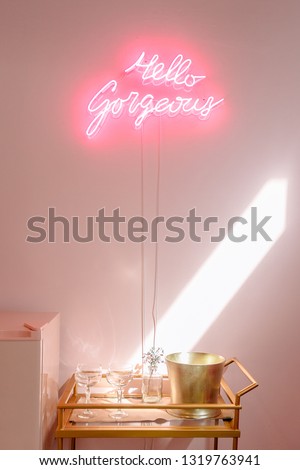 Interior close up of bar cart and wall sign inside pink bridal suite.