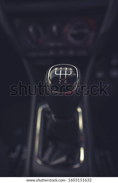 Interior\
close up detail of a modern car. Gear stick with five forward gears\
and reverse in a car with manual\
transmission.