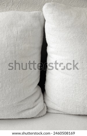 Interior close up photo view of a tiny narroe black hle space in between two 2 big large XXL soft comfortable comfort pillows