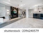 Interior of a condo building community space entry lobby concierge elevators party room kitchen theatre room public use space for apartment building with gym fireplace in the foyer