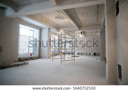 Interior construction of warehouse concrete wall and scaffolding.