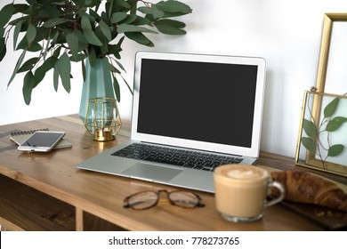 Interior Of A Cozy Feminine Home Office With Laptop Mock-up, Eucalyptus Plant In Vase, Glasses, Coffee Cup, Phone And Frames. Styled Blogger's Workplace