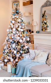 Interior Of Cozy Room Decorated In Christmas Happy New Year Style. No People. An Empty Sofa, Christmas Tree With Presents Under It. Selective Focus. Happy NY Mood