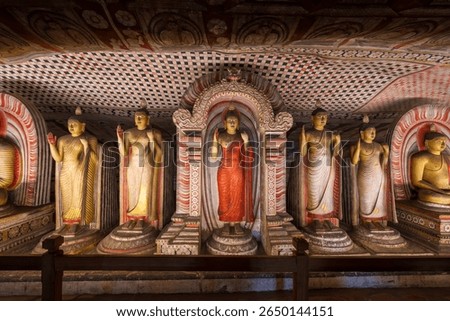 Interior of Dambulla Cave Temple, Sri Lanka, with ancient Buddha statues and mural-covered stone walls. Travel and history.