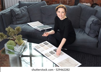 Interior Decorating, Shopping Carpet. Woman Chooses Carpet For The Living Room