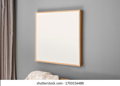 Interior decoration, empty wooden square frame, poster white canvas mock up on a gray wall, living room template angle view - Shutterstock ID 1703156488