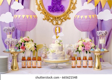 Interior decoration for a kids child birthday is one year in ultra violet trend year purple color. Candy, macaroon, tiered cake, and juices balloon. Anniversary dating one celebration.