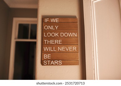 Interior decoration, motivational quote and poster on wall in home for encouragement or inspiration. Art, ideal and wooden sign hanging at window in apartment for background, growth or wallpaper