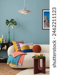 Interior desgin of modern living room interior with mock up poster frame, colorful decorations and accessories, plants, sofa, coffee table. Blue wall. Home decor. Template	