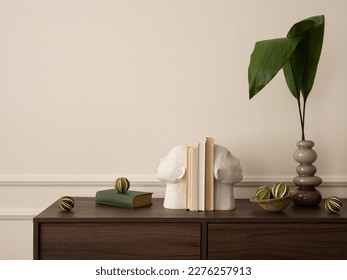 Interior design of aesthetic living room interior with copy space, wooden sideboard, vase with leaves, books, modern sculpture, beige wall with stucco and personal accessories. Home decor. Template.