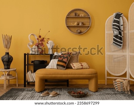 Interior design of cozy living room interior with yellow bench, black consola, patterned pillows, wooden partition wall, vase with dried flowers and personal accessories. Home decor. Template.