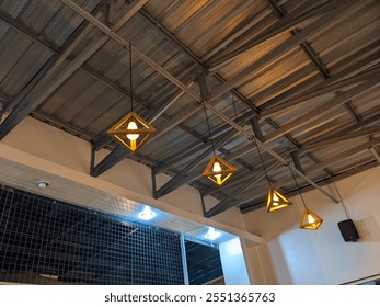 Interior design detail of a minimalist living space.A cluster of contemporary wooden pendant lamps hang from an industrial-style metal ceiling.The design of the lamps add a touch of warmth to the room - Powered by Shutterstock