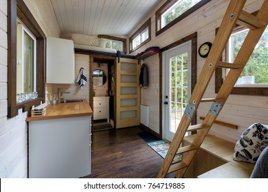 Interior design of a dining room and kitchen in a tiny rustic log cabin.