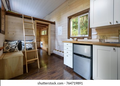Interior design of a dining room and kitchen in a tiny rustic log cabin.
