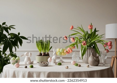Interior design of easter dining room with colorful easter eggs, white hare sculptures, vase with tulips, plants, lamp, beige wall with stucco, gray hen and personal accessories. Home decor. Template.