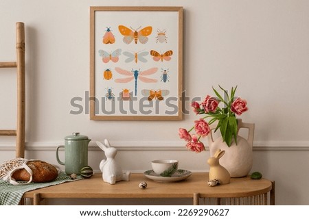 Interior design of easter living room interior with mock up poster frame, glass vase with tulips, wooden sideboard, easter bunny sculpture, bowl, ladder, and personal accessories. Home decor. Template