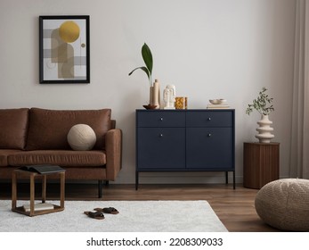 Interior design of harmonized living room with brown sofa, blue commode, coffee table, mock up poster frame, decoration, carpet and personal accessories. Stylish home decor. Template. 
