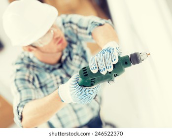 Interior Design And Home Renovation Concept - Man In Helmet With Electric Drill Making Hole In Wall