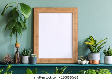 Interior design of living room with brown mock up photo frame on the green shelf with beautiful plants in different hipster and design pots. Elegant personal accessories. Home gardening. Template.  - Shutterstock ID 1608530668