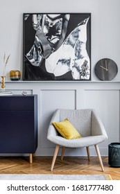 Interior Design Of Living Room With Stylish Navy Blue Commode, Grey Armchair, Pillow, Black Clock, Dried Flower, Modern Paintings, Decoration And Elegant Accessories In Home Decor.