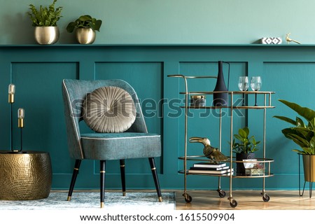Interior design of luxury living room with stylish armchair, gold liquor cabinet, a lot of plants and elegant personal accessories. Green wall panelling with shelf. Modern home decor. Template. 