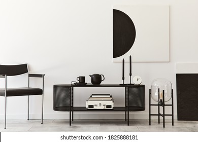 Interior design of modern living room with black stylish commode, chair, mock up art paintings, lamp, book, candlestick, decorations and elegant accessories in home decor. Template. - Shutterstock ID 1825888181