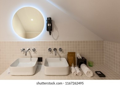 Interior And Design Of The Modern Toilet And Bathroom, Items In The Bathroom Hairdryer, Mirror, Bathrobe, Bath, Sink, Water Taps