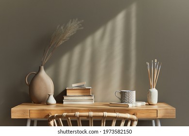Interior design of neutral bohemian living room interior with stylish desk, armchair, dried flowers in vase, book, decoration, office supplies, copy space, notes and personal accessories. Template.