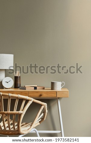 Interior design of neutral bohemian living room interior with stylish desk, armchair, lamp, cup of coffee decoration, office supplies, clock, copy space, notes and personal accessories. Template.
