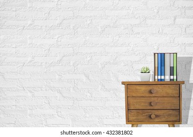 Interior design with plant and stack of books on old wooden dresser.
