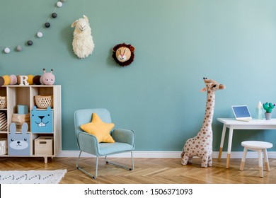 Interior Design Of Scandinavian Childroom With Wooden Cabinet, Mint Armchair, White Desk, A Lot Of Plush And Wooden Toys. Eucalyptus Color Of Background Walls. Plush Animal Head On The Wall. Template 