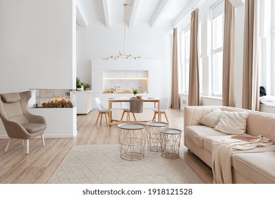 interior design spacious bright studio apartment in Scandinavian style and warm pastel white and beige colors. trendy furniture in the living area and modern details in the kitchen area. - Shutterstock ID 1918121528