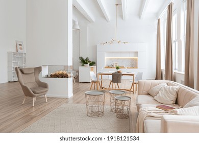 interior design spacious bright studio apartment in Scandinavian style and warm pastel white and beige colors. trendy furniture in the living area and modern details in the kitchen area. - Shutterstock ID 1918121534