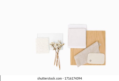 Interior design swatches and samples in neutral color story. Sample board with tile, glass, fabric, wood isolated on white background with copy space