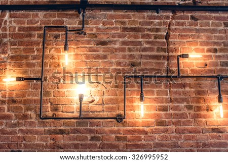 interior design of vintage wall. Rustic design, brick wall with light bulbs and pipes, low lit bar interior