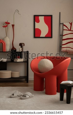 Interior design of warm living room with mock up poster frame, modern red armchair, rack, round pillow, stylish lamp, vase with flowers and personal accessories. Home decor. Template.