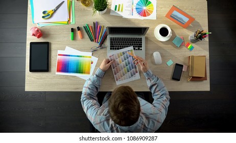 Interior designer choosing color on palette and ordering it online, top view - Shutterstock ID 1086909287