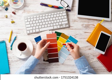 Interior Designer Choosing Colors From Swatches At Wooden Desk. Office Workplace With Computer Keyboard. Selection Of Color Palette For Design. Professional House Renovation And Interior Redesign.