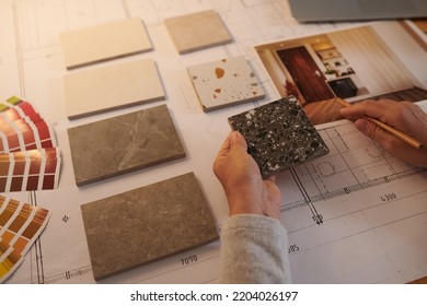 Interior designer choosing samples of floor tiles for project - Powered by Shutterstock