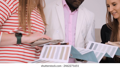 Interior designer collaborates with diverse couple to select wall colors for their home renovation. Diverse perspectives enrich design choices. Emphasis on inclusive and diverse home styling. - Powered by Shutterstock