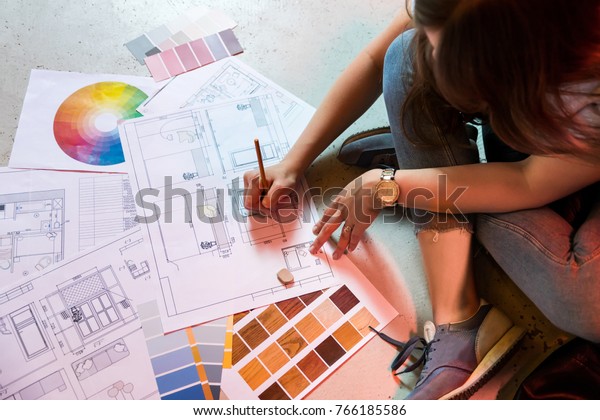 Interior designer\
draws plan with art\
tools