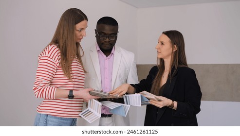 Interior designer helps interracial couple choose best colors for home wall painting and renovation. Diverse duo plans vibrant home renovation. Thoughtful renovation collaboration showcased. - Powered by Shutterstock