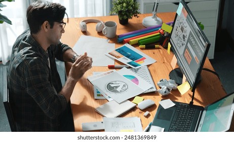 Interior designer looking at laptop and designing color while looking at palette at meeting table with laptop, computer and paper placed. Close up of business man working on color design. Symposium. - Powered by Shutterstock