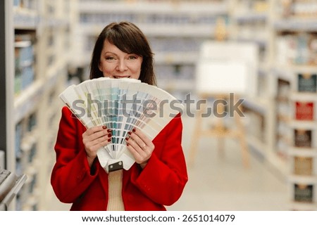 Interior designer smiling while holding a vibrant color palette in a bustling hardware store, exploring options for home improvement projects