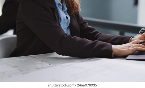 Interior designer studying architectural blueprints in office to translate accurate measurements of physical spaces in order to create new floor plan. CAD specialist working with drafts. Close up. - Powered by Shutterstock