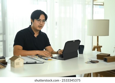 Interior designer working with a digital tablet or reviewing design project at office - Powered by Shutterstock