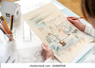 Interior designer working on color hand drawings of interior at work place. Photo of young designers work concept